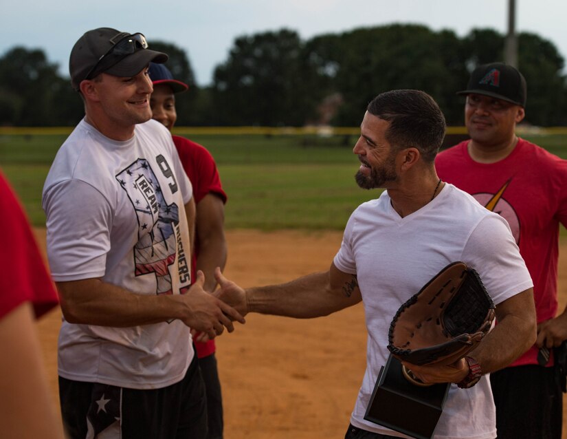 Tony Arroyo, 633rd Force Support Squadron fitness center director, hands the trophy to the 30th Intelligence Squadron softball team during the intramural softball championship at Joint Base Langley-Eustis, Virginia, Aug. 30, 2018.