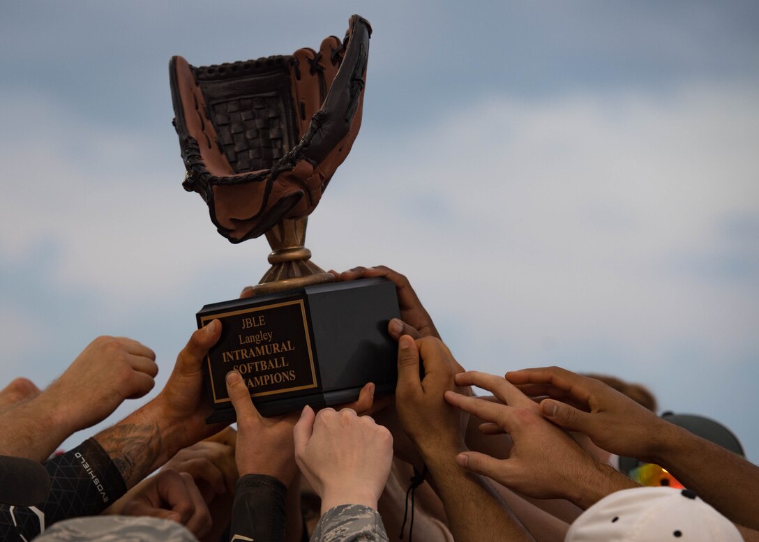 The 30th Intelligence Squadron softball team holds the trophy after winning the intramural softball championship at Joint Base Langley-Eustis, Virginia, Aug. 30, 2018.