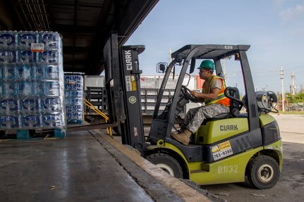 A member of the Puerto Rico militia, Luis Suarez, picks up water from a loading dock at a Federal Emergency Management Agency distribution center in Ponce, Puerto Rico, Oct. 26, 2017. FEMA, assisted by the National Guard and militia, distributes water and food to people throughout the area. Ohio Guard members recently practiced relief techniques.