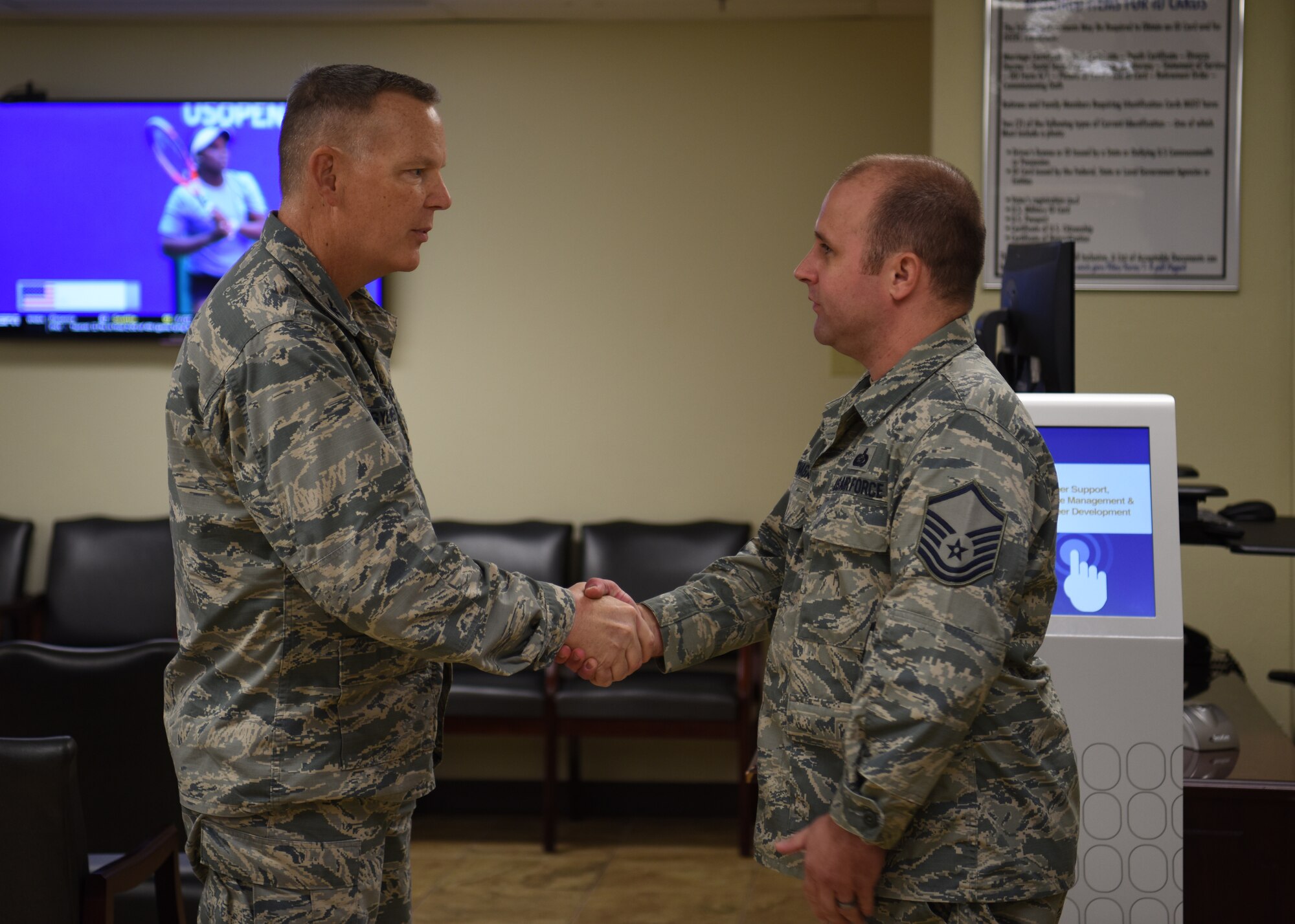 U.S. Air Force Master Sgt. Sean O’Hagan, 56th Force Support Squadron section chief, receives a challenge coin from U.S. Air Force Col. Robert Sylvester, 56th Mission Support Group commander, for his key role in finalizing the implementation of the check-in kiosk Aug. 29, 2018 at Luke Air Force Base, Ariz.