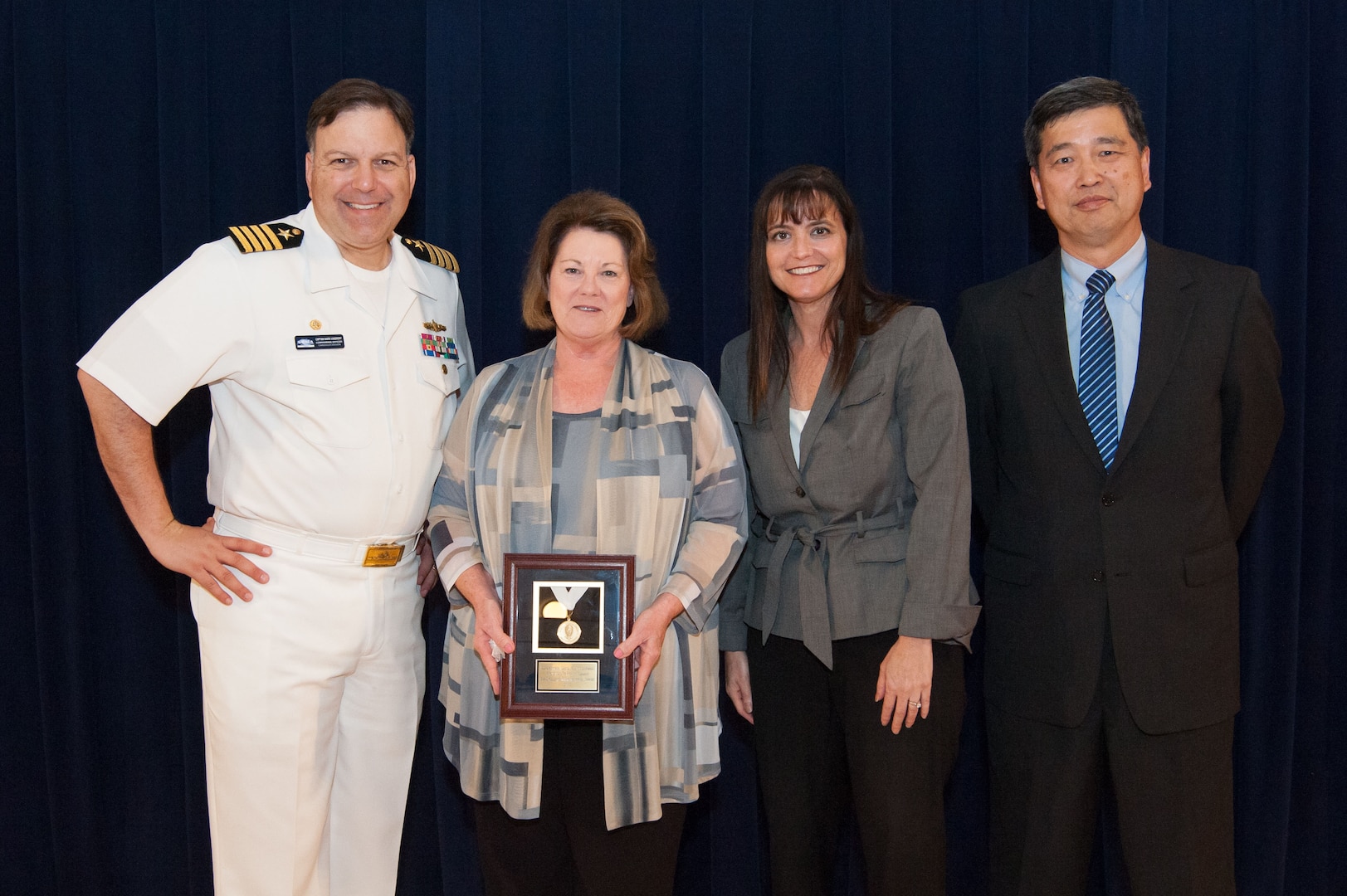 Rita M. Terhaar, Carderock's Human Resources director, receives the Rear Adm. Grace M. Hopper Award for excellence in organizational support at the Naval Surface Warfare Center, Carderock Division Honor Awards ceremony Aug. 28, 2018, in West Bethesda, Md. From left to right: Commanding Officer Capt. Mark Vandroff; Terhaar; Tamar Gallagher, head of Carderock's Corporate Operations Department; and Dr. Paul Shang, Carderock's acting technical director. (U.S. Navy photo by Nicholas Brezzell/Released)