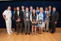 The MK 18 Mod 2 Lithium Battery Test Team receives the Rear Adm. Benjamin F. Isherwood Award for exceptional fleet support at the Naval Surface Warfare Center, Carderock Division Honor Awards ceremony Aug. 28, 2018, in West Bethesda, Md. Members of the team are, pictured left to right after Commanding Officer Capt. Mark Vandroff: Earl Armstrong, Adam Dolezal, Thomas Hays, Louis Levine, Jacob Helmers, Jessica Schwartz, Joseph Praydis, Julie Anne Simmons and Usman Sorathia. Also pictured is Dr. Paul Shang, acting technical director, and Jeff Mercier, head of the Platform Integrity Department. Awardee Christopher Mealy is not pictured. (U.S. Navy photo by Nicholas Brezzell/Released)