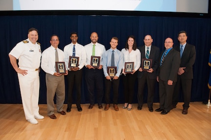 The LHA 6 Total Ship Survivability Trial (TSST) Team receives the Donald F. McCormack Award, which recognizes a small group for collaboration excellence across the Warfare Centers, at the Naval Surface Warfare Center (NSWC), Carderock Division Honor Awards ceremony Aug. 28, 2018, in West Bethesda, Md. From left to right: Commanding Officer Capt. Mark Vandroff; NSWC Carderock™s Laurent Edgell, Jeevan Nalli, Christopher Perich and Michael Persinger; NSWC Philadelphia™s Hannah Demboski and Robert High; Jeff Mercier, head of the Platform Integrity Department; and Dr. Paul Shang, acting technical director. (U.S. Navy photo by Nicholas Brezzell/Released)