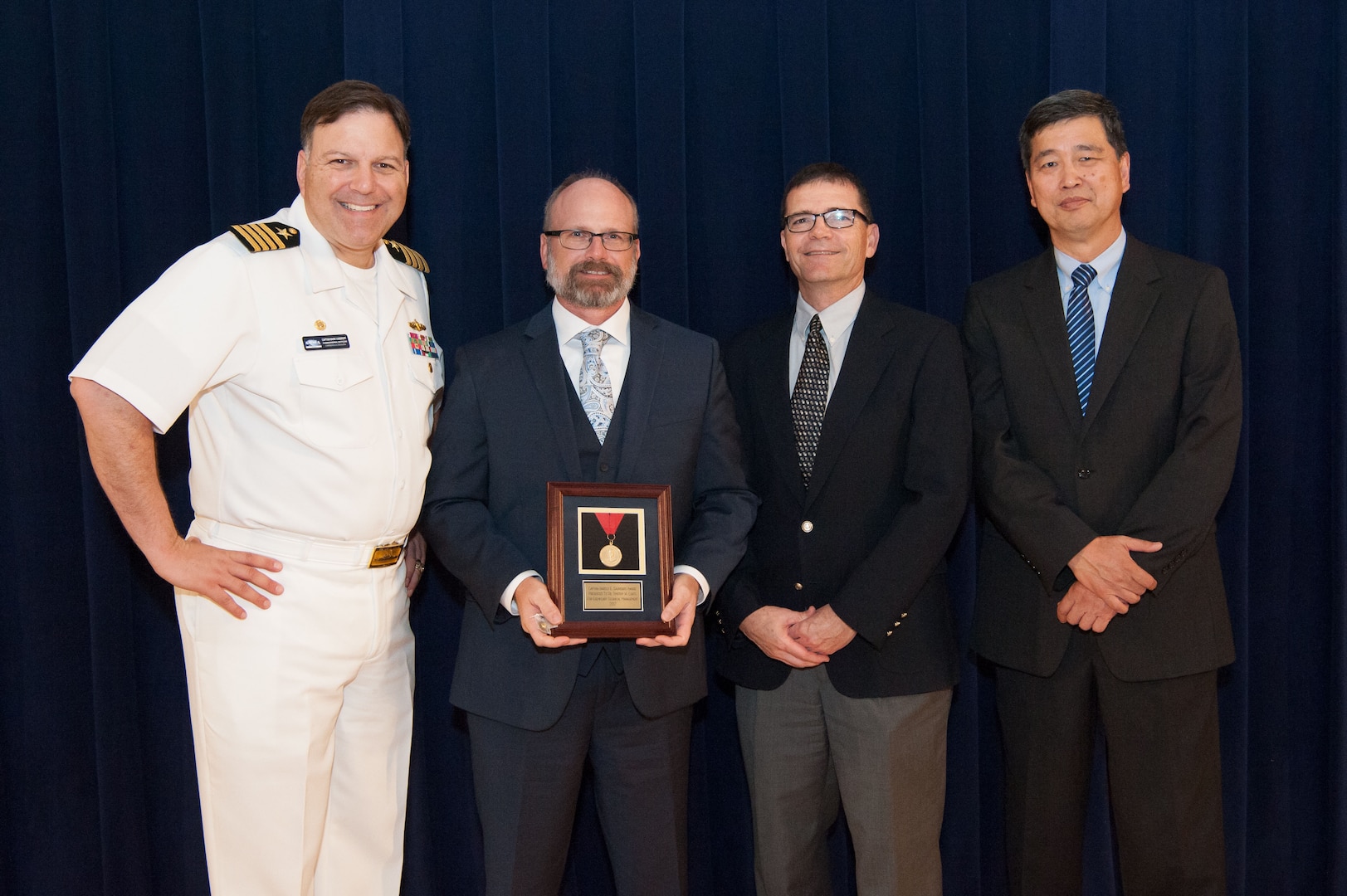 Dr. Timothy Coats, lead for Combatant Craft Division's Unmanned Maritime Mobility Group, receives the Capt. Harold E. Saunders Award for exemplary technical management at the Naval Surface Warfare Center, Carderock Division Honor Awards ceremony Aug. 28, 2018, in West Bethesda, Md. From left to right: Commanding Officer Capt. Mark Vandroff; Coats; Steve Ouimette, deputy head of the Naval Architecture and Engineering Department; and Dr. Paul Shang, acting technical director. (U.S. Navy photo by Nicholas Brezzell/Released)