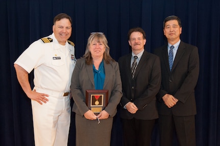 Amy Le Doux, Carderock's customer advocate for the Virginia-class Program Office (PMS450), receives the Capt. Harold E. Saunders Award for exemplary technical management at the Naval Surface Warfare Center, Carderock Division Honor Awards ceremony Aug. 28, 2018, in West Bethesda, Md. From left to right: Commanding Officer Capt. Mark Vandroff; Coats; Mike Slater, division head of Carderock's Signatures Measurement Technologies and Systems Division; and Dr. Paul Shang, acting technical director. (U.S. Navy photo by Nicholas Brezzell/Released)