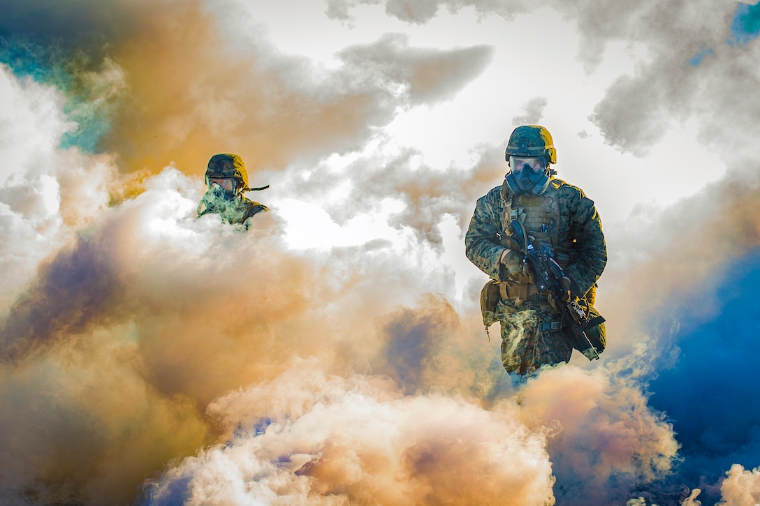 Marines walk through a cloud of tear gas.