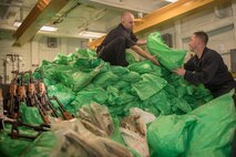 Sailors stack a cache of more than 1,000 AK-47 automatic rifles aboard the guided-missile destroyer USS Jason Dunham (DDG 109).