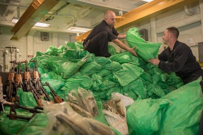 GULF OF ADEN (Aug. 30, 2018) Sailors stack a cache of more than 1,000 AK-47 automatic rifles aboard the guided-missile destroyer USS Jason Dunham (DDG 109). The ship's visit, board, search and seizure team seized the weapons from a skiff during a flag verification boarding as part of maritime security operations. Dunham is deployed to the U.S. 5th Fleet area of operations in support of naval operations to ensure maritime stability and security in the Central Region, connecting the Mediterranean and the Pacific through the western Indian Ocean and three strategic choke points. (Photo by Mass Communication Specialist 3rd Class Jonathan Clay)