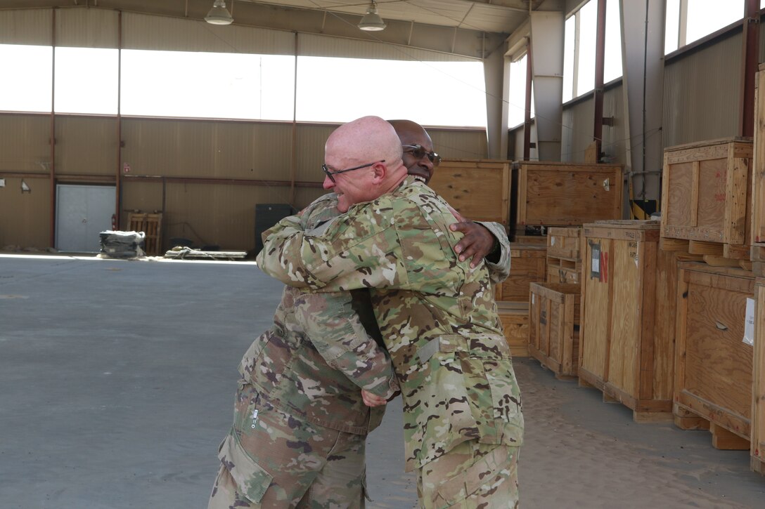 Army Staff Sgt Robert Morneau, right, a crew chief assigned to 1st Battalion, 126th Aviation Regiment (General Support Aviation Battalion), embraces Army Sgt 1st Class Giovanni Ford, the 449th Combat Aviation Brigade Headquarters and Headquarters Company’s supply sergeant at Camp Buehring, Kuwait, Aug. 21, 2018. The two noncommissioned officers are childhood comrades that haven’t seen each other for 30 years until they ran into each other on their 2017-2018 deployment in support of Operations Inherent Resolve and Spartan Shield. Army photo by Capt. Briana McFarland
