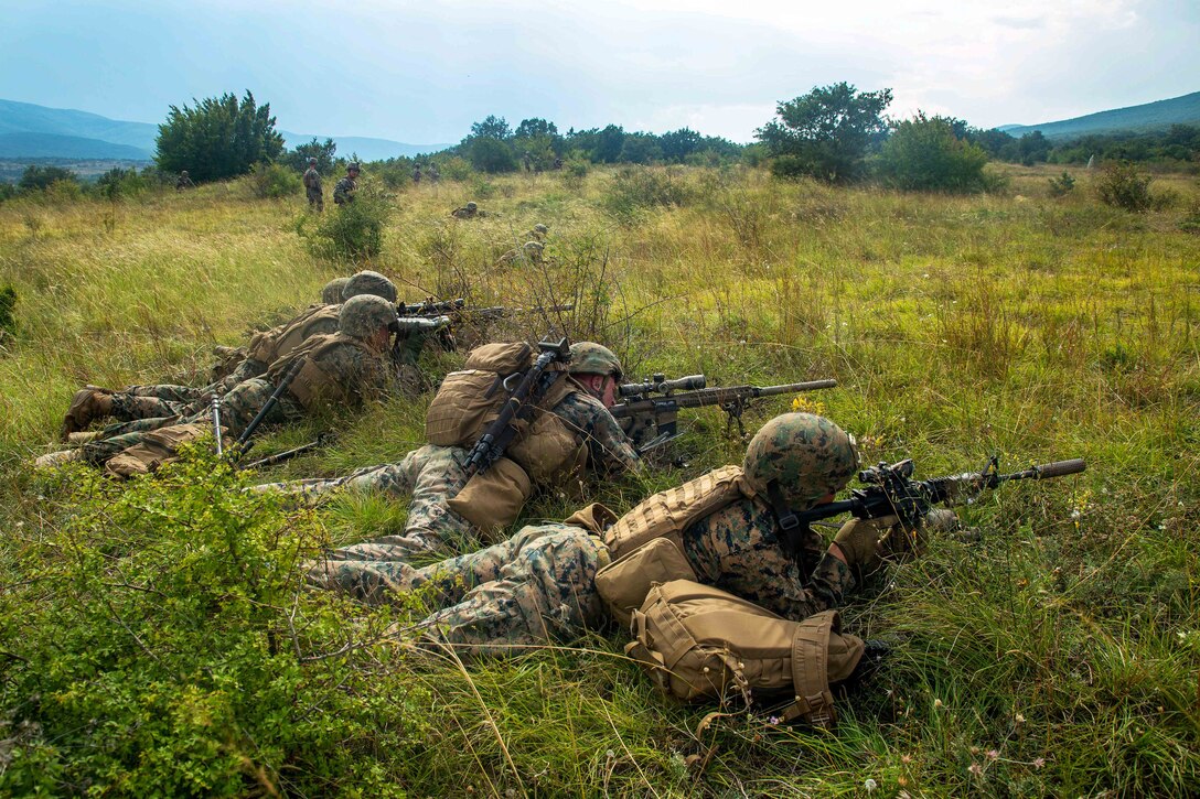 Marines establish a firing line while engaging targets at a live-fire range.