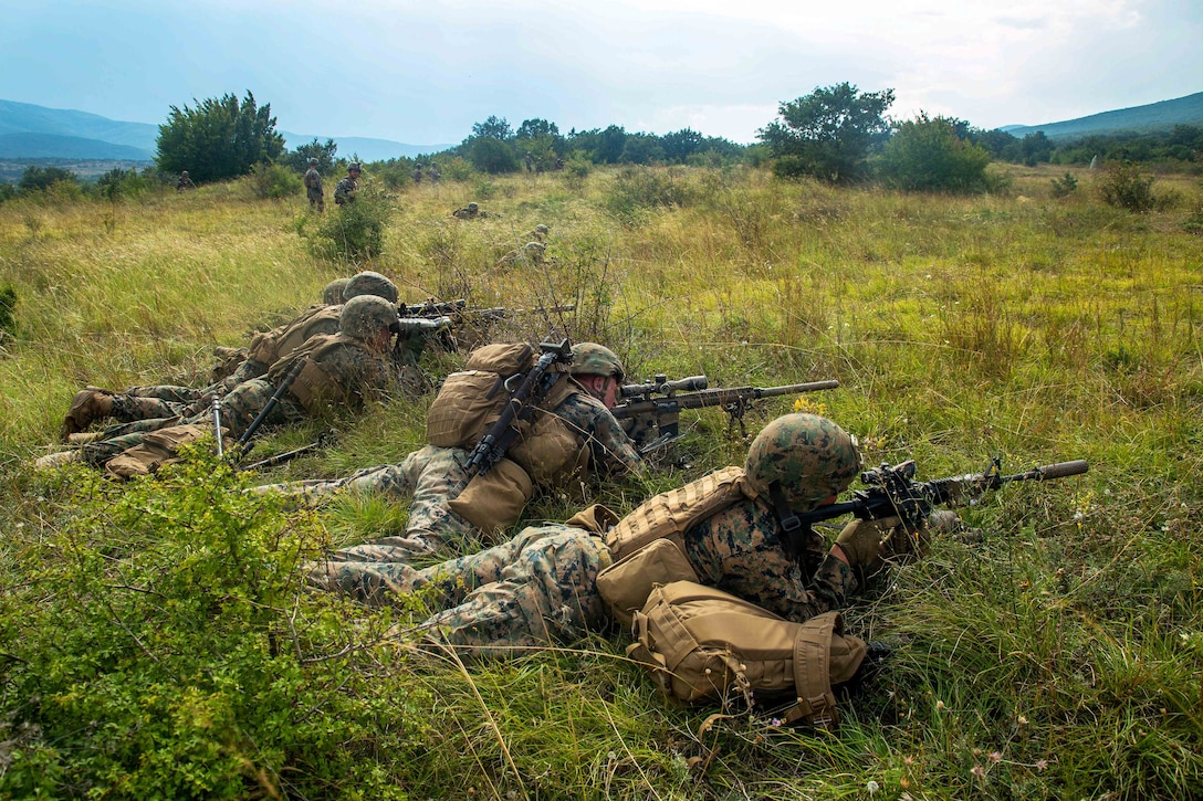 Marines establish a firing line while engaging targets at a live-fire range.