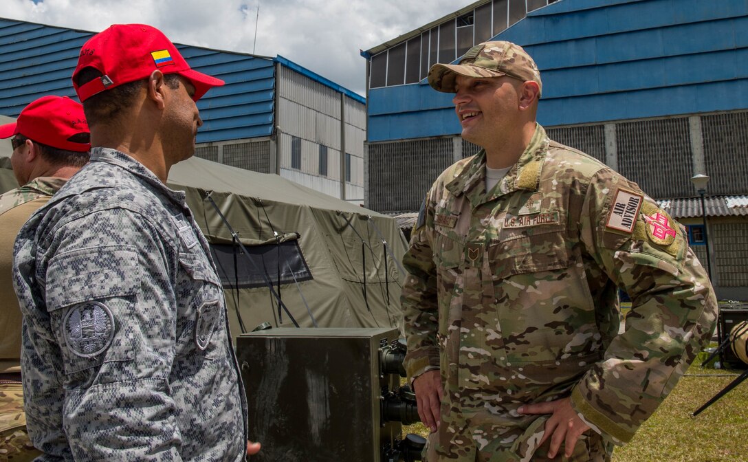 U.S. Air Force Tech. Sgt. Giacomo Zignago, right, 571st Mobility Support Advisory Squadron independent duty medical technician, speaks with a medical technician from the Colombian Air Force during the opening ceremony of Exercise Angel de los Andes, Sept. 3, 2018, at Air Combat Command-5, Rionegro, Colombia.  Angel de los Andes is a search and rescue exercise hosted by Colombia involving 12 partner nations that will work together in a joint environment and focus on exercising search and rescue, aeromedical evacuation and casualty evacuation operations. (U.S. Air Force Photo by Staff Sgt. Robert Hicks)