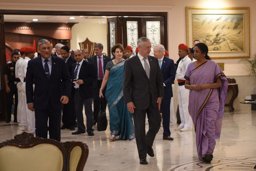 Defense Secretary James N. Mattis walks with Indian Defense Minister Nirmala Sitharaman and a group of people down a hallway.