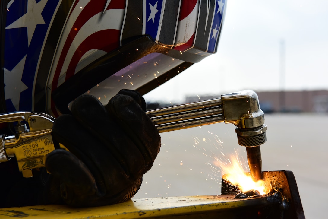 Senior Airman David Corona, a 28th Maintenance Squadron metals technician, cuts a steel plate off of a stand with an oxyacetylene torch at Ellsworth Air Force Base, S.D., Aug. 23, 2018. The metals technology shop runs 24-hour operations to provide different metals technologies for all squadrons on base. (U.S. Air Force photo by Airman John Ennis)
