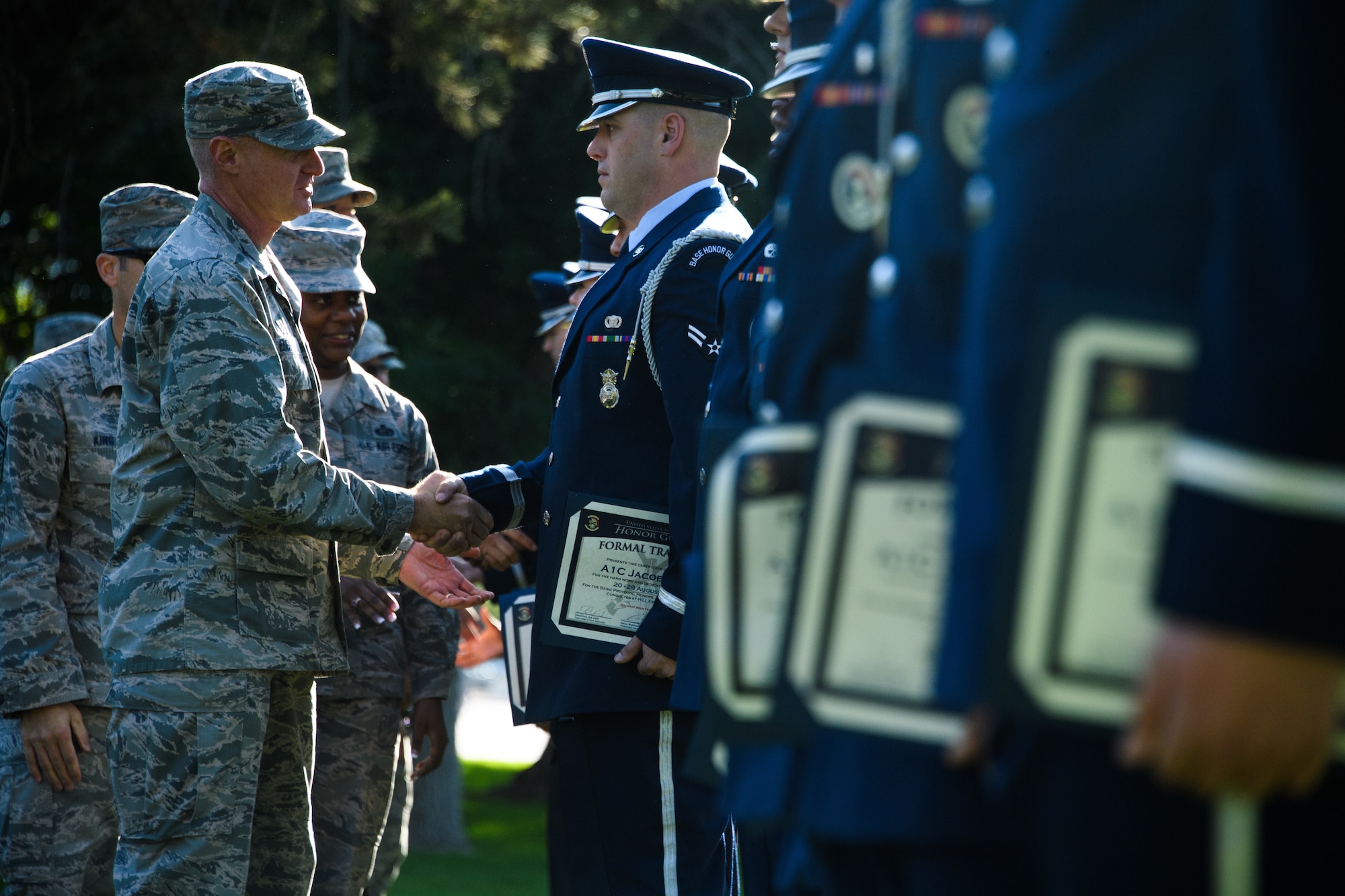 Col. Jon Eberlan, 75th Air Base Wing commander, shakes hands with Airman 1st Class Jacob Faine after an honor guard graduation ceremony at Hill Air Force Base, Utah, Aug. 29, 2018. Twenty Airmen from Hill, F. E. Warren, Mountain Home and Nellis Air Force Bases graduated from the 80-hour course instructed by a U.S. Air Force Honor Guard Mobility Training Team from Joint Base Anacostia-Bolling, Washington D.C. (U.S. Air Force photo by R. Nial Bradshaw)