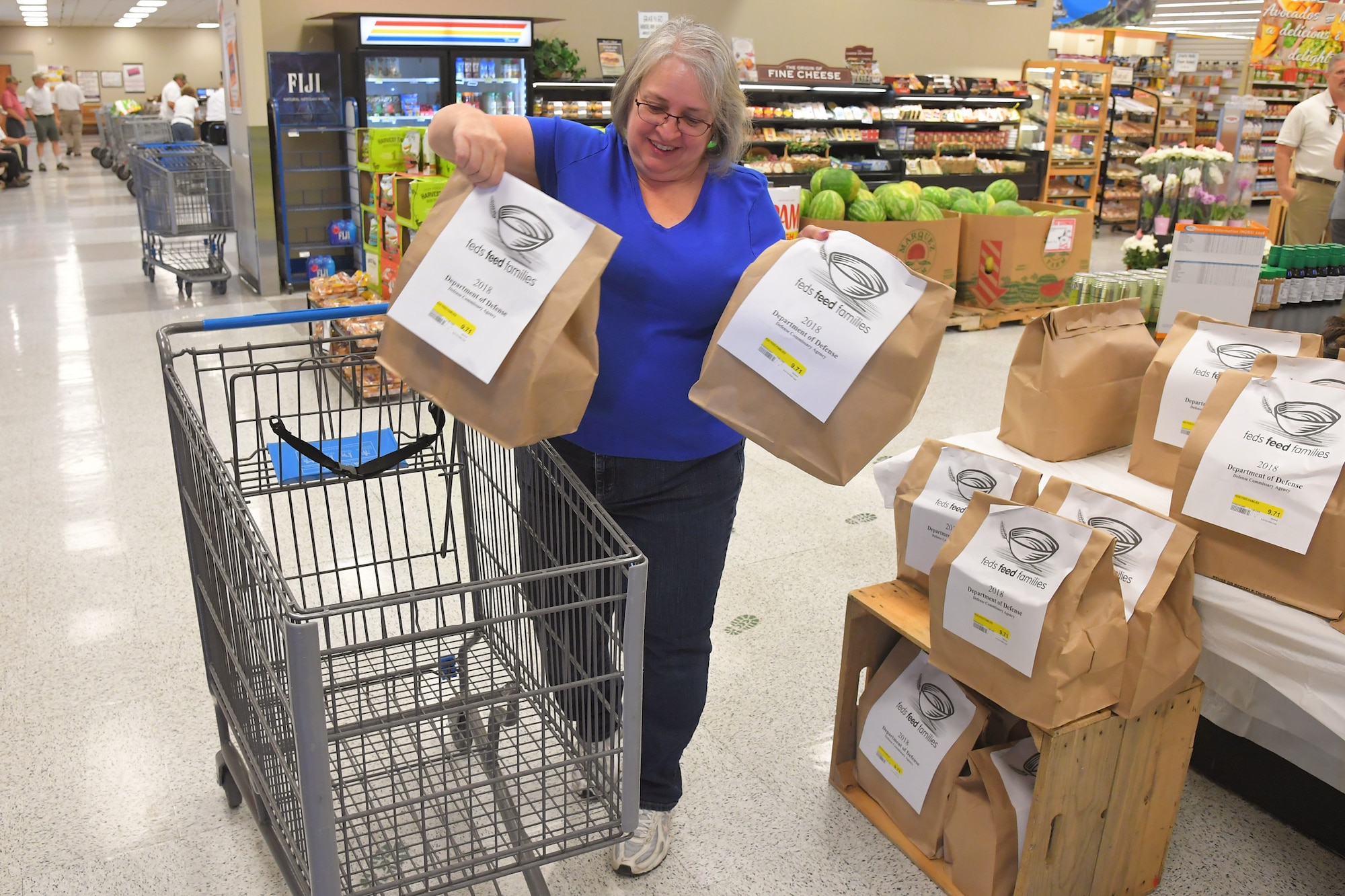 Kim Lingel, patron at the Hill Commissary, participates in the 2018 Feds Feed Families program by purchasing bags of food for donation Sept. 5, 2018, at Hill Air Force Base, Utah. (U.S. Air Force photo by Todd Cromar)