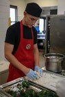 Pfc. Dominic Marimonti prepares the ingredients of his main dish for the Food Specialist of the Quarter competition at Camp Kinser, Okinawa, Japan, Aug. 30, 2018. Marimonti is a food service specialist with 3rd Marine Logistic Group Headquarters Regiment and is a native of St. Louis, Missouri. He participated in the competition to expand his culinary knowledge and test his abilities as a food specialist. (U.S. Marine Corps photo by Pfc. Kindo Go)
