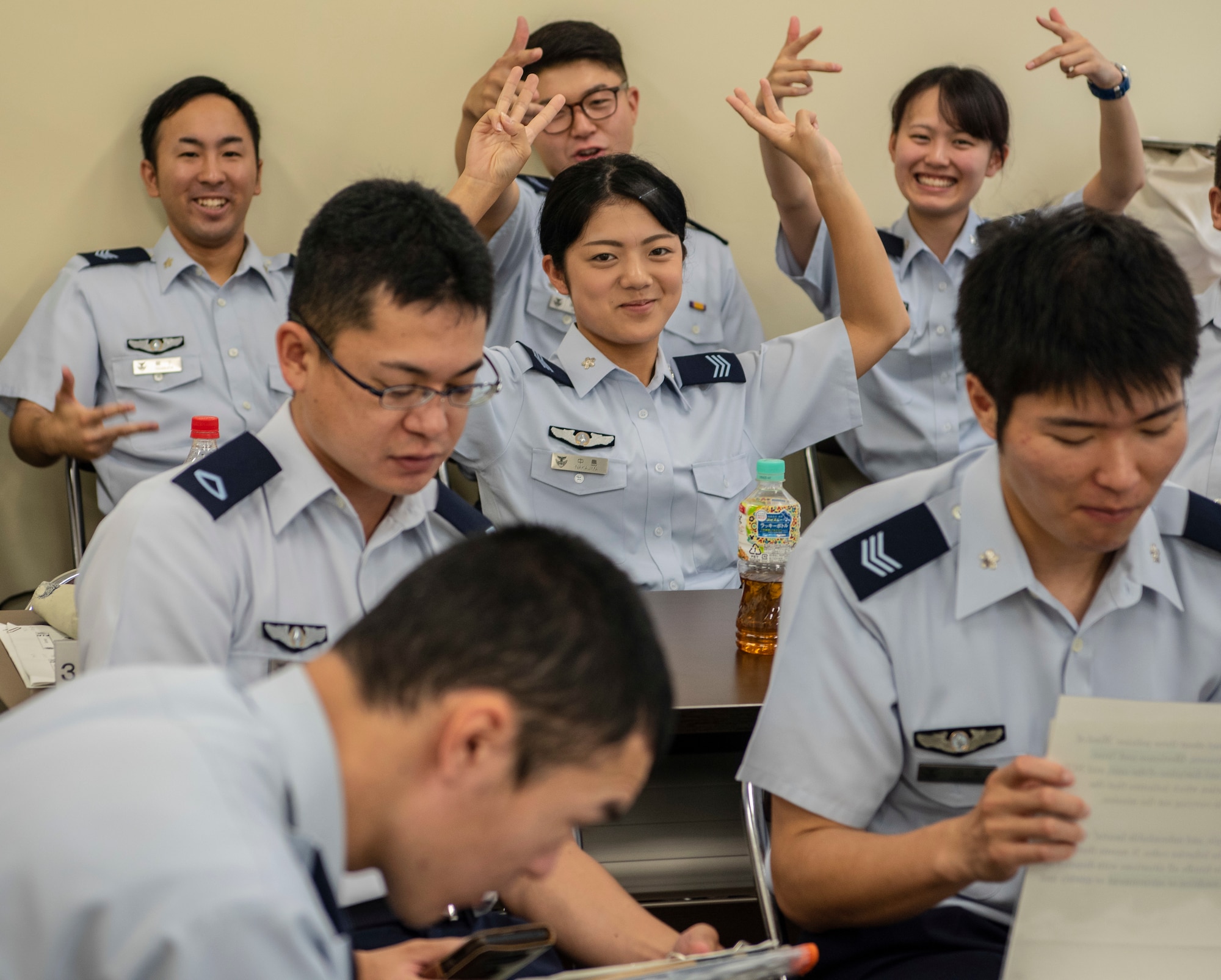 Japan Air Self-Defense Force contestants strike a pose before going on stage during the JASDF English Competition at Misawa Air Base, Japan, Aug. 30, 2018. Approximately 35 members participated and each group prepared a slideshow presentation in English for the judges. The enlisted personnel’s piece involved the rank structure and JASDF heritage. The officers talked about threats Japan faces. (U.S. Air Force photo by Airman 1st Class Xiomara M. Martinez)