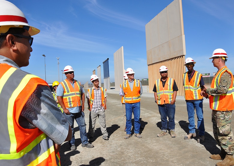 Col. Aaron Barta, U.S. Army Corps of Engineers Los Angeles District commander, far right, talks to Corps’ team members about the border infrastructure project in front of design prototypes near the San Diego and Mexico International Border during an Aug. 30 site visit in San Diego County, California.