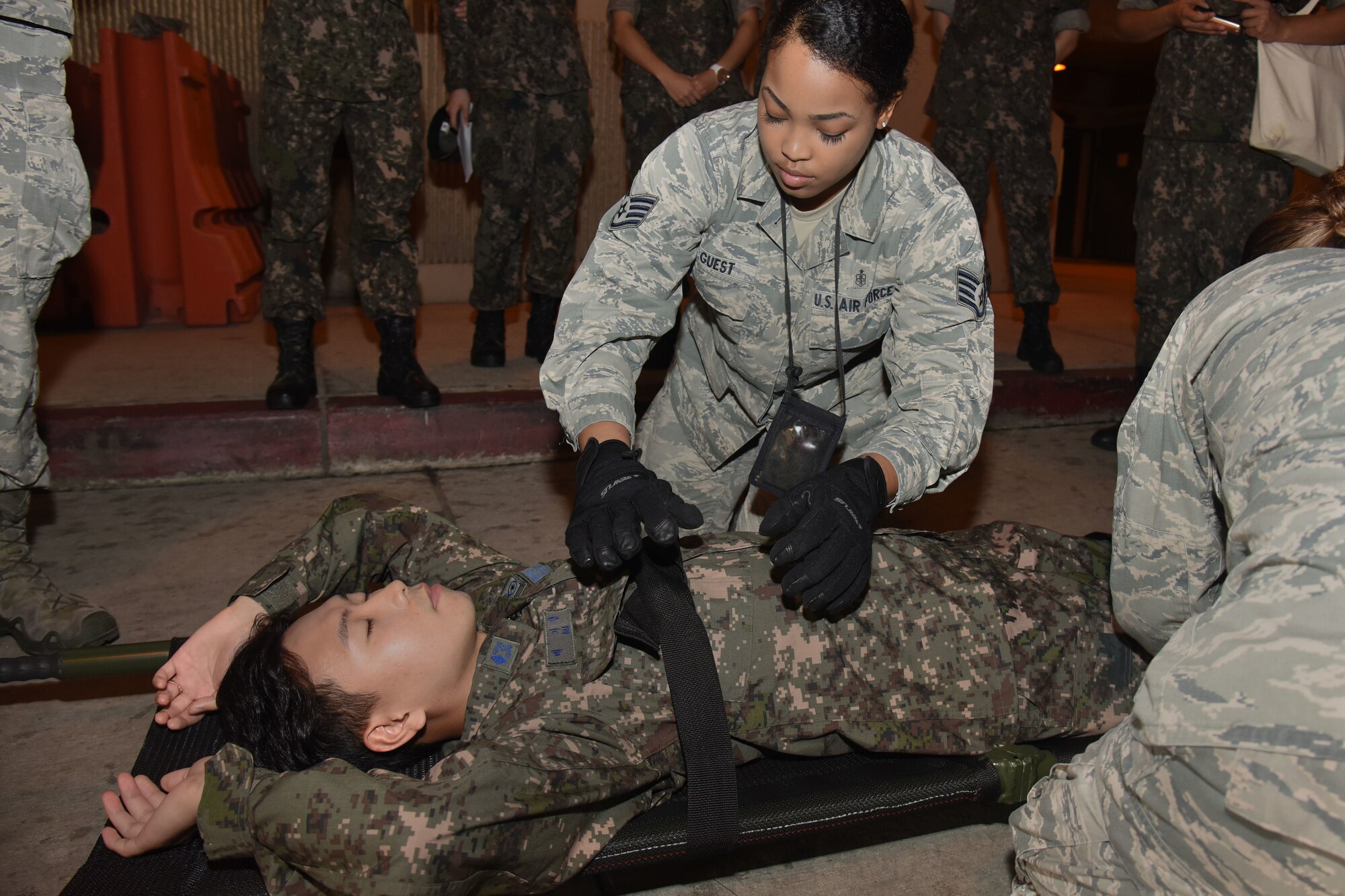 U.S. Air Force Staff Sgt. Lakita Guest, 51st Medical Group flight medicine technician, straps down Republic Of Korea Air Force 2nd Lt. Garam Bae during an ambulance evacuation demonstration at Osan Air Base, Republic of Korea Sept. 6, 2018. Flight technicians from the 51st demonstrated techniques used to transport medical patients to aircraft on the flightline, which allowed a hands-on experience for the Republic of Korea Aeromedical Center students to exchange ideas, experiences and ask questions. (U.S. Air force photo by Tech Sgt. Ashley Tyler)