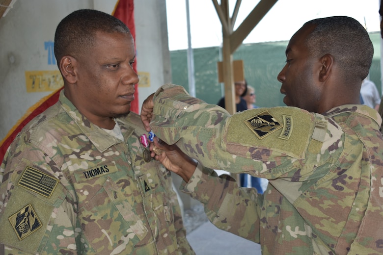 The Superior Civilian Service Award and NATO Medal are presented to Lawrence W. Thomas by Afghanistan District Commander, Col. Jason E. Kelly.