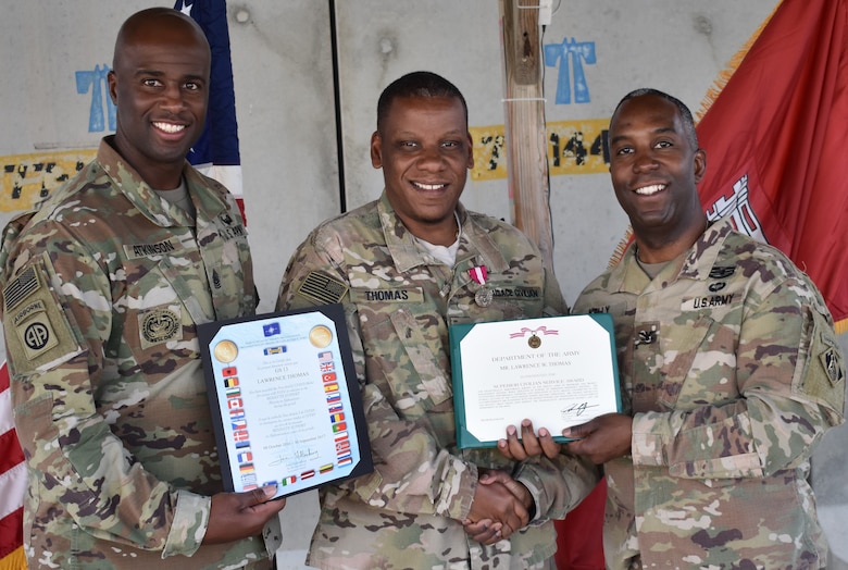 Command Sergeant Major Nathaniel Atkinson and Col. Jason Kelly, Afghanistan District Commander, present the Superior Civilian Award and NATO Medal certificates, along with a handshake to Lawrence W. Thomas, Deputy Chief of Programs and Project Management Division.