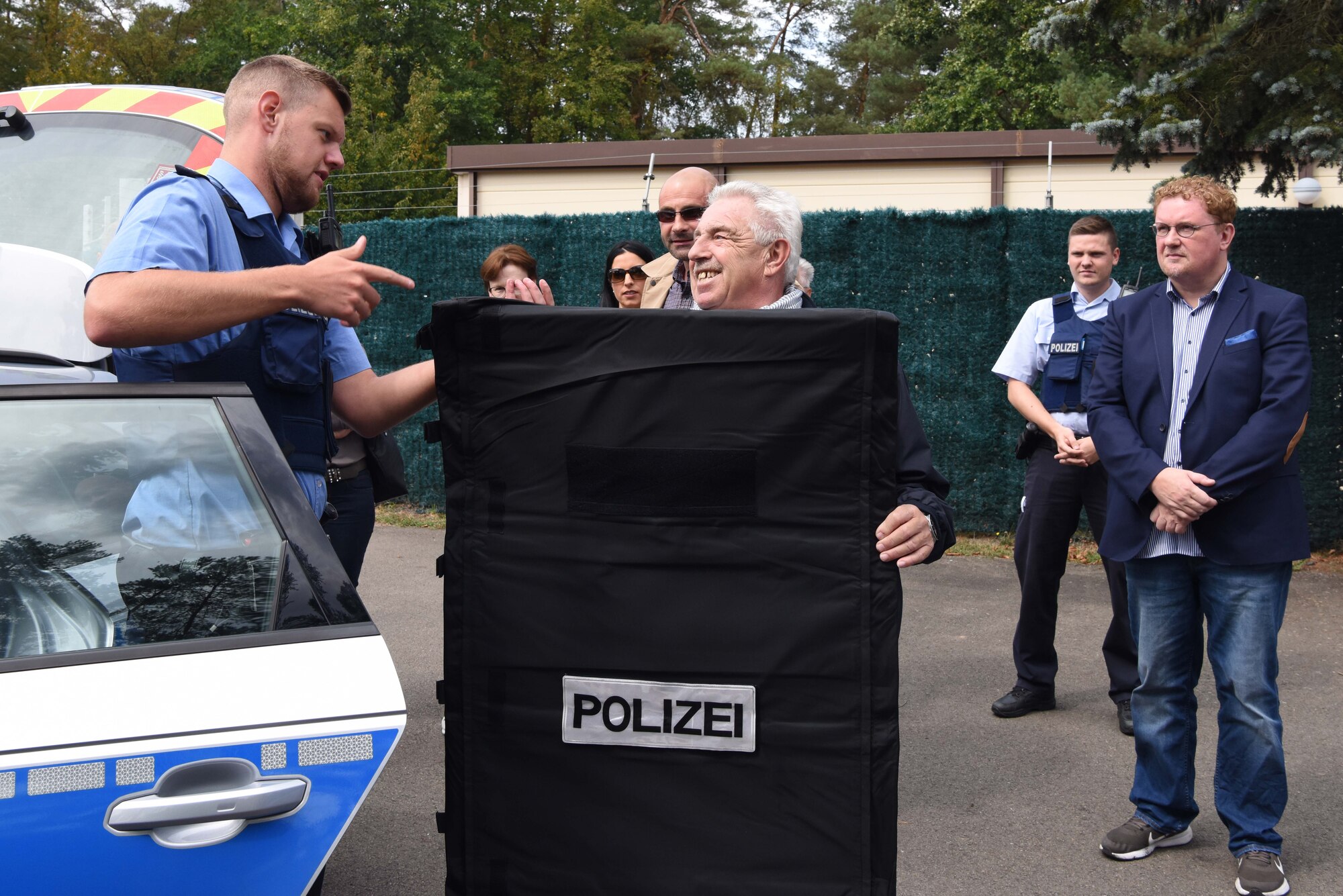 Alfons Lehr holds up a riot shield during a base tour on Ramstein Air Base, Germany, Aug. 31, 2018. The German distinguished visitors learned how Polizei share jurisdiction with U.S. military police and  were hands-on with their equipment.