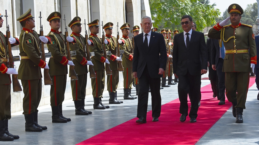 Defense Secretary James N. Mattis walks with an Afghan leader in front of Afghan troops.