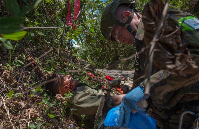 A medic from the Brazilian Air Force provides aid to a triage patient during a simulation as part of the Angel de los Andes exercise Sept. 5, 2018 at German Olano Air Base, Colombia. Airmen from Colombia, Peru, Brazil and the United States worked with Colombian firefighters and civil defense team to air evacuate more than 25 people during a simulated aircraft crash. (U.S. Air Force photo by Staff Sgt. Robert Hicks)