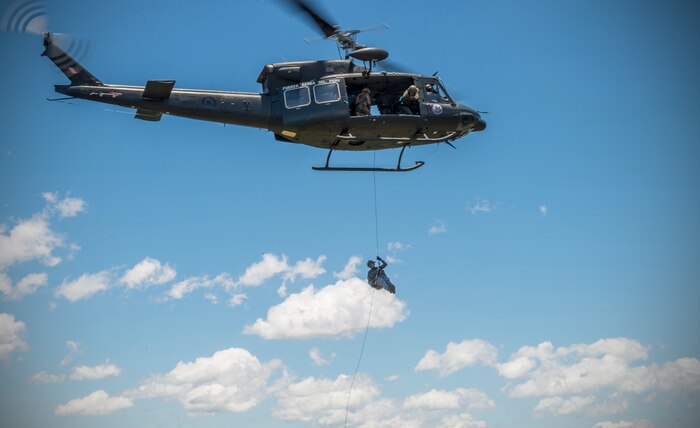 An Airman from the Colombian Air Force rappels from a Peruvian helicopter during exercise Angel de los Andes Sept. 5, 2018 at German Olano Air Base, Colombia. Airmen from Colombia, Peru, Brazil and the United States worked with Colombian firefighters and civil defense team to air evacuate more than 25 people during a simulated aircraft crash. (U.S. Air Force photo by Staff Sgt. Robert Hicks)