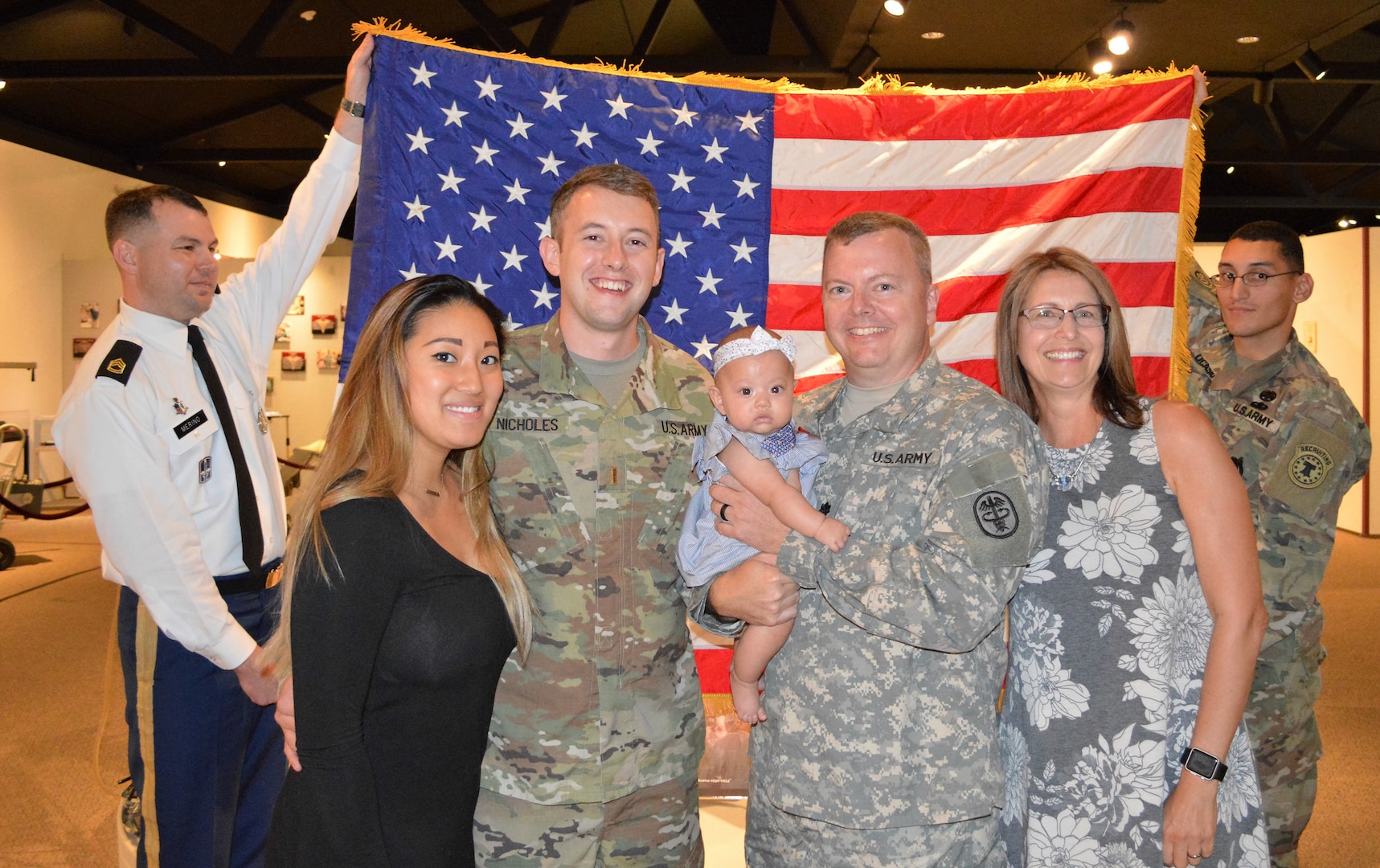 The Nicholes family poses following a commissioning ceremony July 20 at the Army Medicine Department Museum on Joint Base San Antonio-Fort Sam Houston, Texas, where Army 2nd Lt. Marc A. Nicholes (center left) administered the oath of office to swear-in his father, Army Reserve Lt. Col. Andrew “Andy” Nicholes (center right).  They are joined by (l. to r.) Army Sgt. 1st Class Irvin Merino, a health care recruiter with the Army Medical Recruiting Station Houston, Marc’s wife, Kelly, Andy’s wife, Lorraine, and Staff Sgt. Joel Ocasio, a health care recruiter with the Army Medical Recruiting Station Houston.