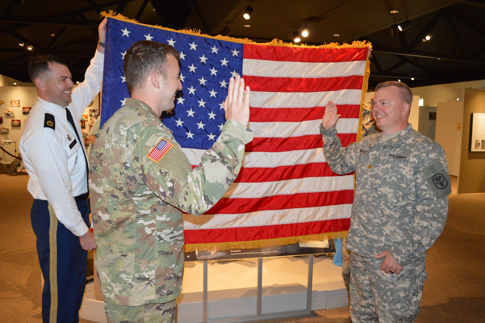 Army 2nd Lt. Marc A. Nicholes (center left), administers the oath of office to swear-in his father, Army Reserve Lt. Col. Andrew “Andy” Nicholes (center right) during a commissioning ceremony July 20 at the U.S. Army Medicine Department Museum on Joint Base San Antonio-Fort Sam Houston.  Holding the U.S. flag is Army Sgt.1st Class Irvin Merino (far left) and Staff Sgt. Joel Ocasio (not shown), both health care recruiters with the Army Medical Recruiting Station Houston.
