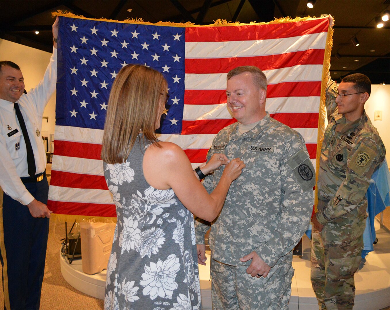 Lorraine Nicholes pins rank on the uniform of her husband, Army Reserve Lt. Col. Andrew "Andy" Nicholes (center right), during a commissioning ceremony July 20 at the U.S. Army Medicine Department Museum at Joint Base San Antonio-Fort Sam Houston.