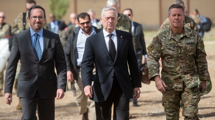 Three men walk toward the camera.