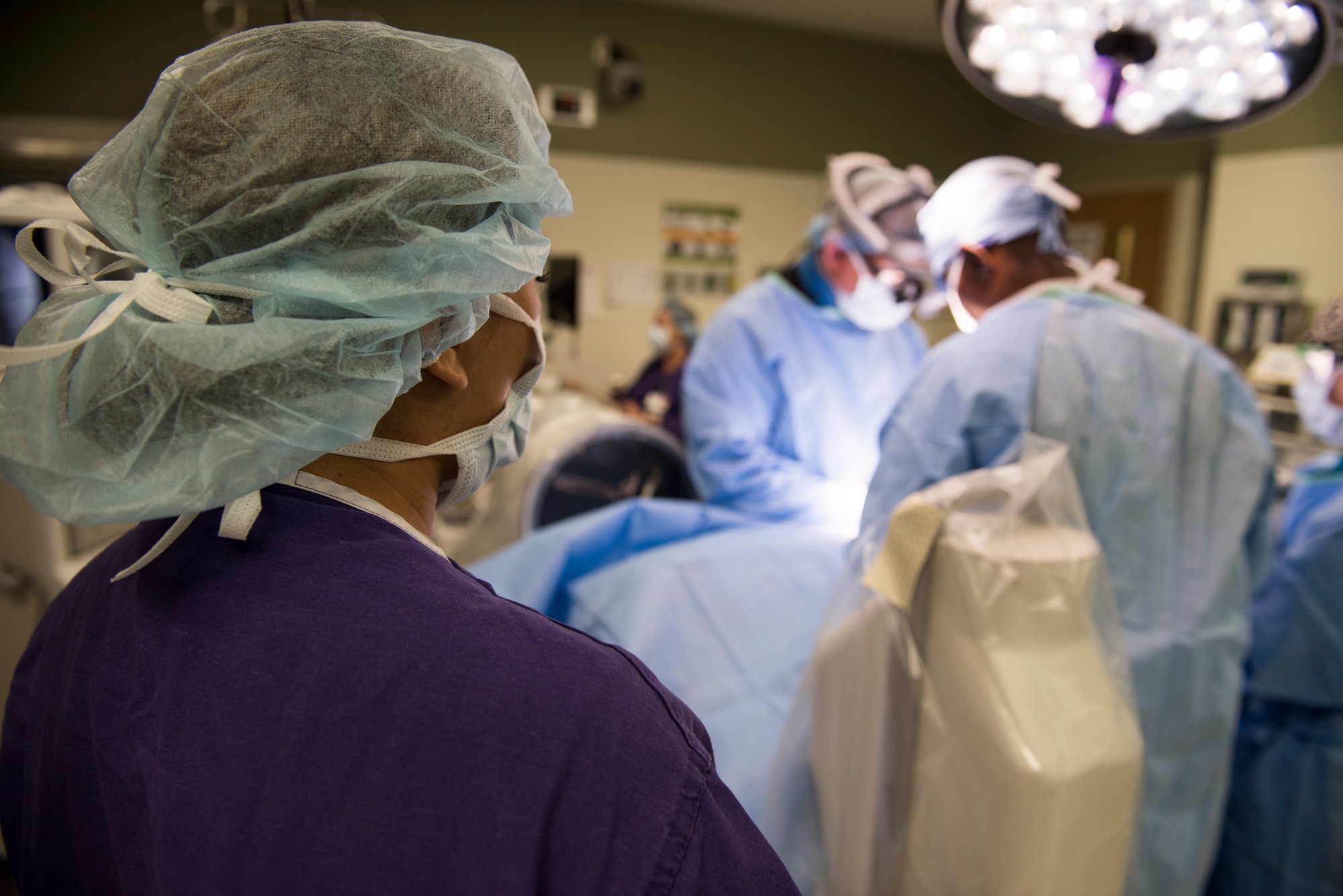 Airman 1st Class Kayla Vait, 99th Medical Group aerospace medical student, observes a team of Airmen perform orthopedic spine surgery at Nellis Air Force Base, Nevada, Aug. 27, 2018. Students get the opportunity to observe surgeries to give them a better understanding of their job. (U.S. Air Force photo by Airman 1st Class Andrew D. Sarver)