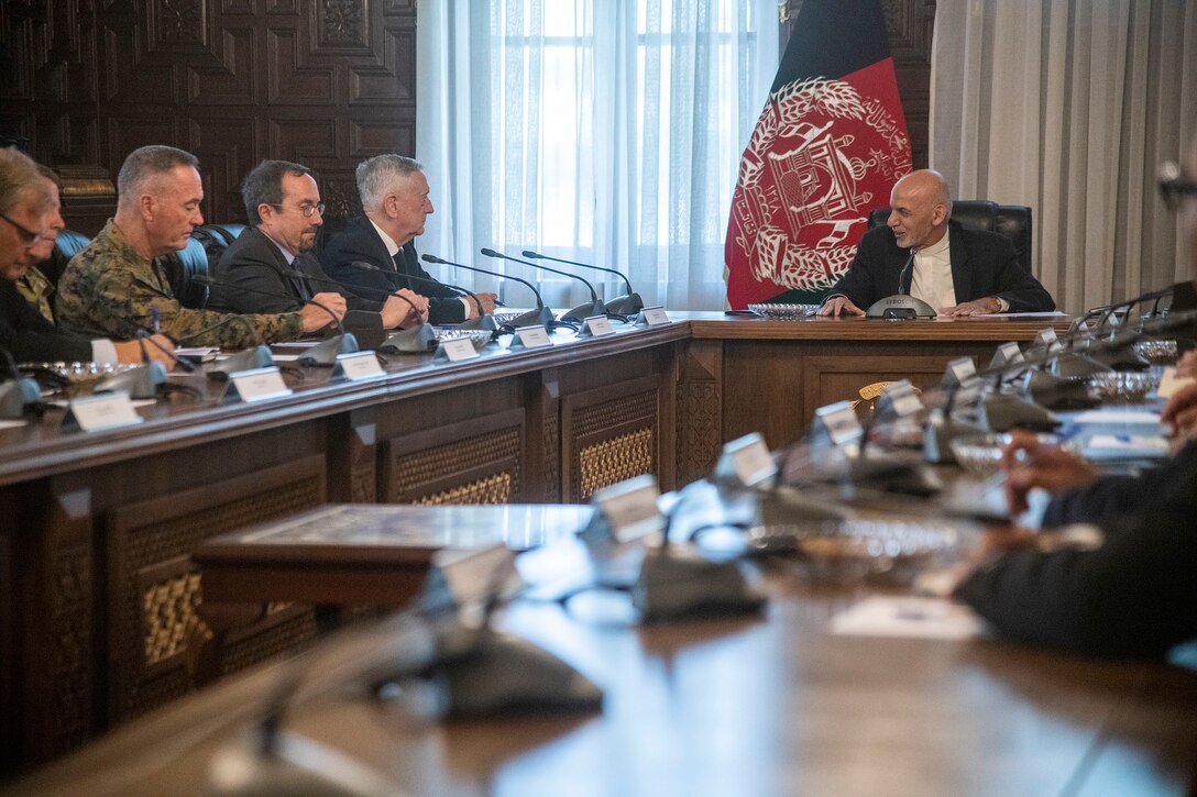 U.s defense leaders meet with the Afghan president at a long table.