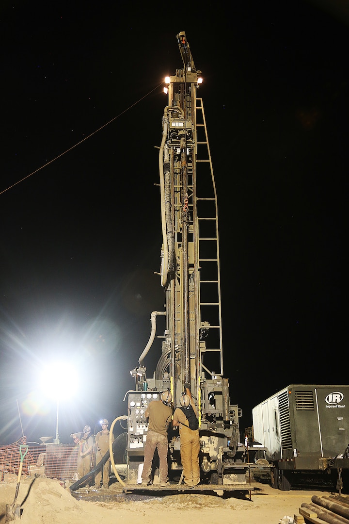 A U.S. Navy Seabee connects the top head and drill steel during water well drilling exploration operations in Riohacha, Colombia.