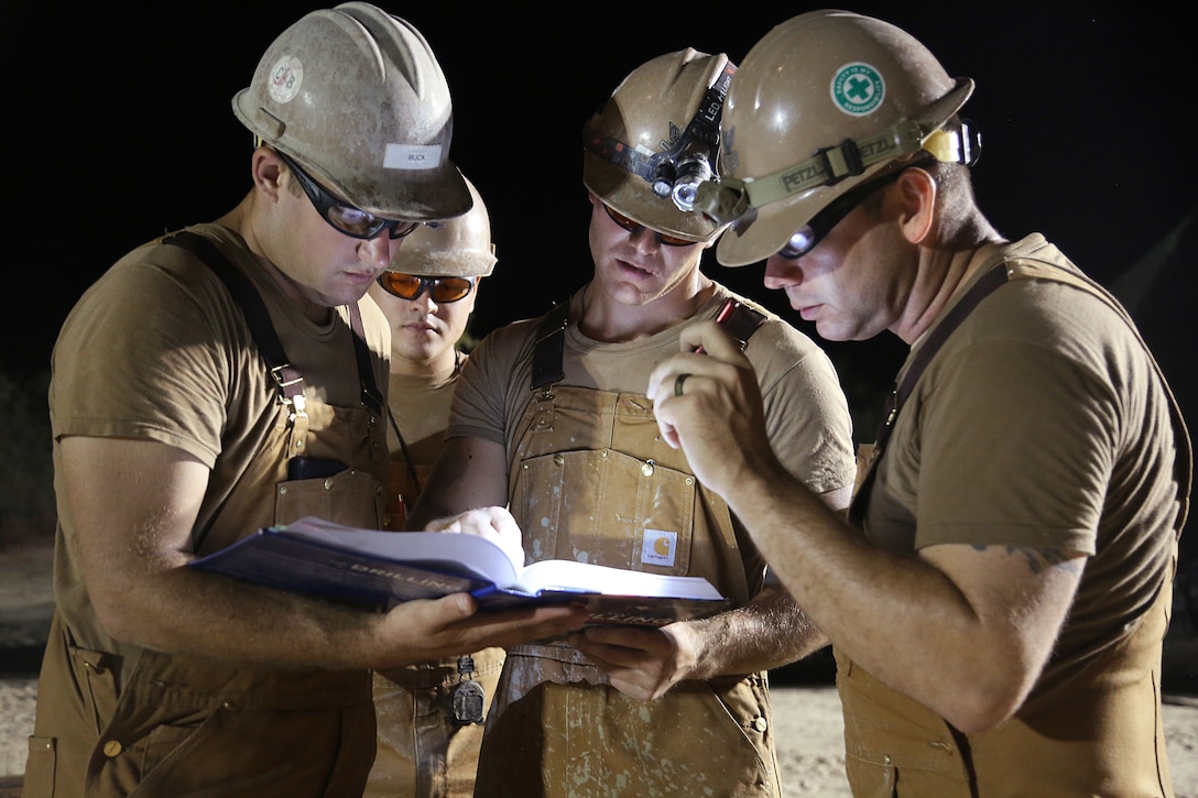 U.S. Navy Seabees review a drilling manual during water well drilling exploration operations in Riohacha, Colombia.