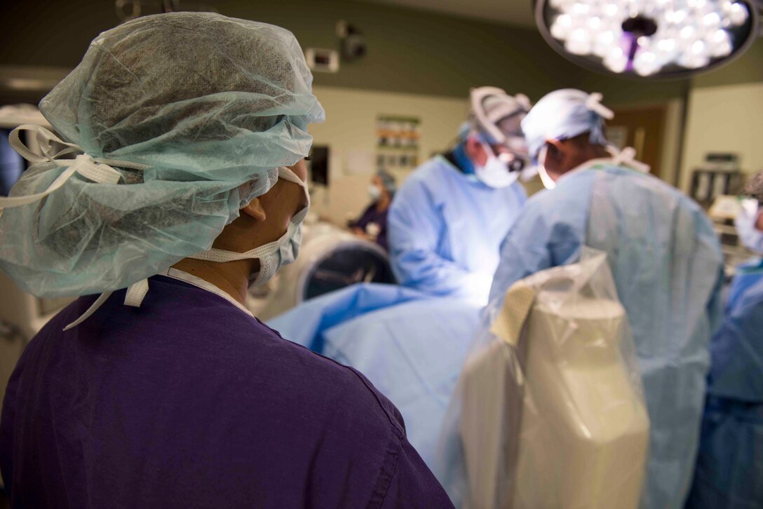 Medical students observe surgery in operating room.