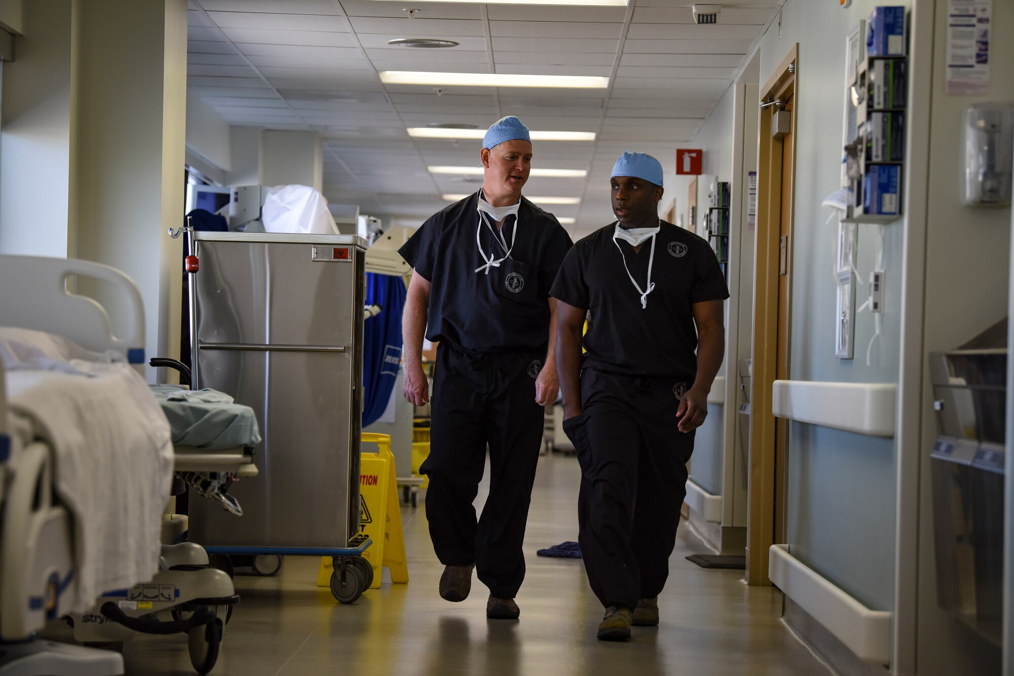 Col. (Dr.) Edward Anderson and Maj. (Dr.) Bryan Lawson, 99th Medical Group orthopedic spine surgeons, walk down a hallway at Nelis Air Force Base, Nevada, Aug. 23, 2018. Anderson and Lawson have known each other for nearly a decade. (U.S. Air Force photo by Airman 1st Class Andrew D. Sarver)