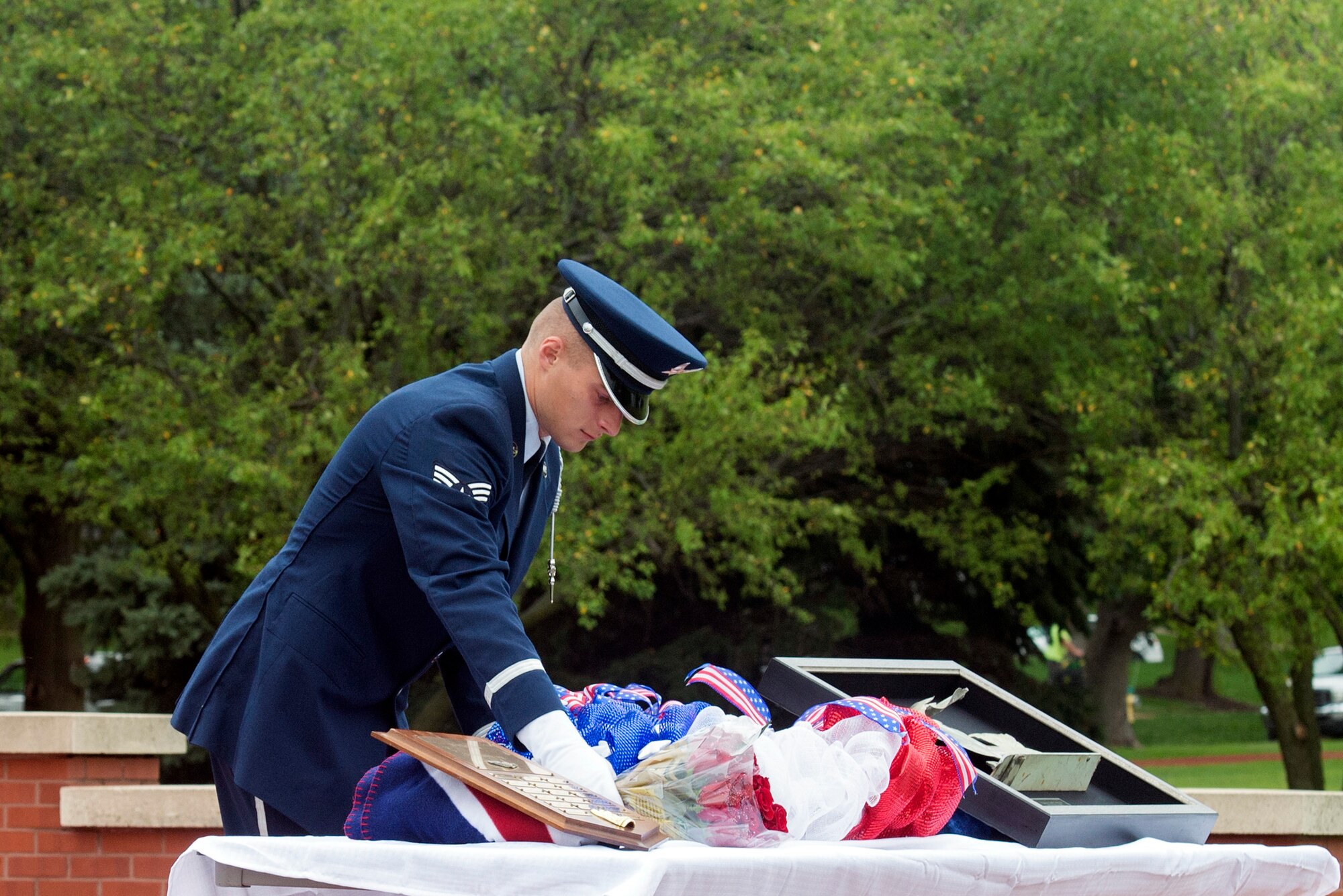 Senior Airman Zachary, Offutt Air Force Base Honor Guard member, lays a wreath and roses next to a piece of C-130 wreckage from 60528, an aircraft which was shot down in the Cold War, during a remembrance ceremony held Aug. 30, 2018, at Offutt Air Force Base, Nebraska. The ceremony was attended by members of the 97th Intelligence Squadron, the Prop Wash Gang, a group of retired ISR operators, family members and fellow wingman to the fallen. (U.S. Air Force photo by L. Cunningham)