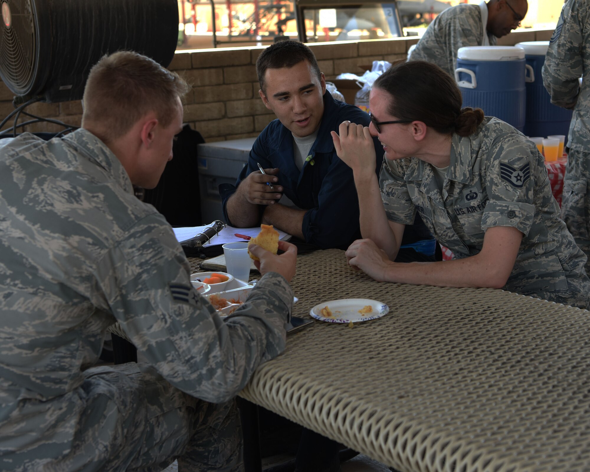 Airmen from the 56th Fighter Wing partake in a meal and converse during the Flightline Feast Sept. 6, 2018, at Luke Air Force Base, Ariz.