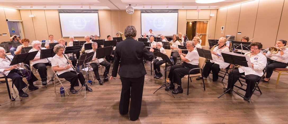 WAF Band historian Jeananne Nichols conducts the WAF Band and current US Air Force Band members during a concert at the Armed Forces Retirement Home in Washington, D.C.