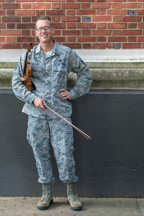 Master Sgt. Luke Wedge poses in front of Historic Hangar 2, Home of the U.S. Air Force Band
