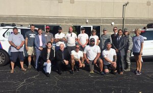 Former Air Force Office of Special Investigations Special Agent Adele Loar, standing sixth from right, is joined by fellow cross-country walkers, in white t-shirts, and current Special Agents, including Col. Garry Little, 1st Field investigations Region Commander, next to Loar, and Lt. Col. Andrea O'Connor, 10th Field Investigations Squadron Commander, second from right, during a break in the walkers 1,000 mile cross-country trek to raise awareness of wounded veterans' mental health and other issues. (U.S. Air Force photo by Amy Rollins, 88 ABW/PA)
