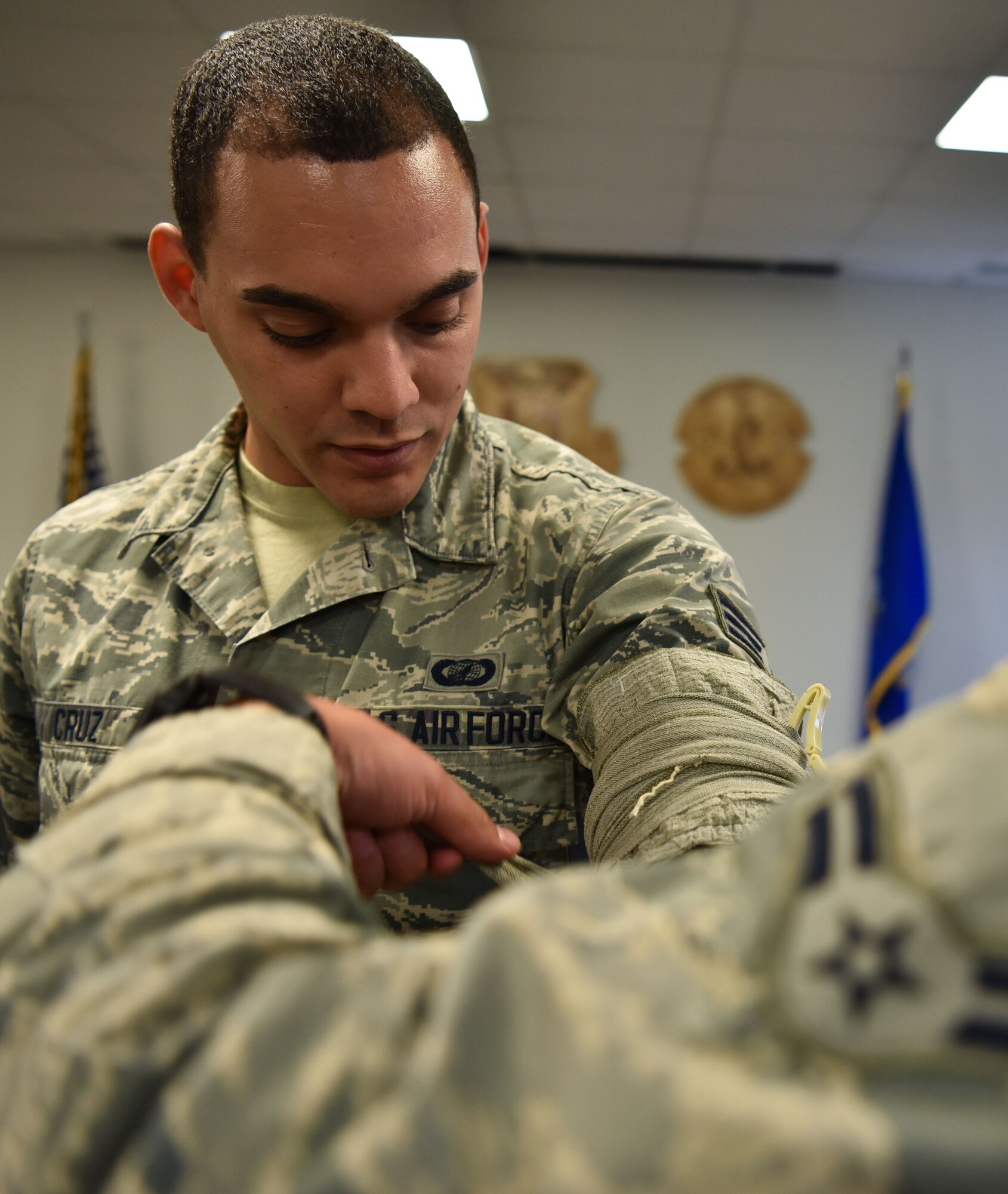 Senior Airman Timothy Cruz, 90th Comptroller Squadron financial services technician, has his arm wrapped with a bandage as part of a Self-Aid Buddy care class, Aug. 10, 2018, on F.E. Warren Air Force Base, Wyo. Before anyone is allowed to go on a deployment, they must first go through a course on SABC. The training consists of classroom instruction and hands-on tactics. The purpose of the course is to provide Airmen with the basic knowledge of injury care. (U.S. Air Force Photo by Airman 1st Class Braydon Williams)