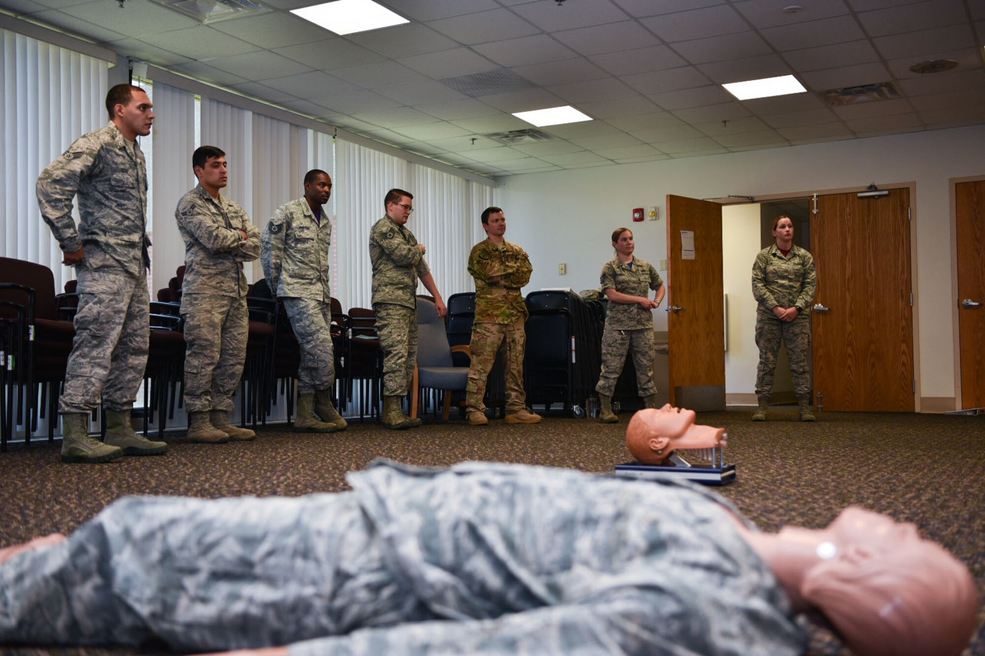 90th Missile Wing Airmen stand listening to the Self-Aid Buddy Care instructor Aug. 10, 2018, on F.E. Warren Air Force Base, Wyo. SABC can be a lifesaving tool in a deployed location or in the back yard. It is important for everyone to receive the necessary required refresher courses because the skills may be used at any time. (U.S. Air Force Photo by Airman 1st Class Braydon Williams)
