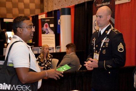 Staff Sgt. Jacob D. Varvel, U.S. Army health care recruiter, speaks with an attendee of the PAINWeek 2018 conference at The Cosmopolitan of Las Vegas. Varvel, from the Mountain Region Physician Recruiting Station, was on hand with other representatives from the Las Vegas Medical Recruiting Station and the 6th Medical Recruiting Battalion to promote the benefits and opportunities of a career in Army Medicine. For more information on the Army's more than 90 medical specialties go to healthcare.goarmy.com. (U.S. Army Photo by Andrew Lynch)