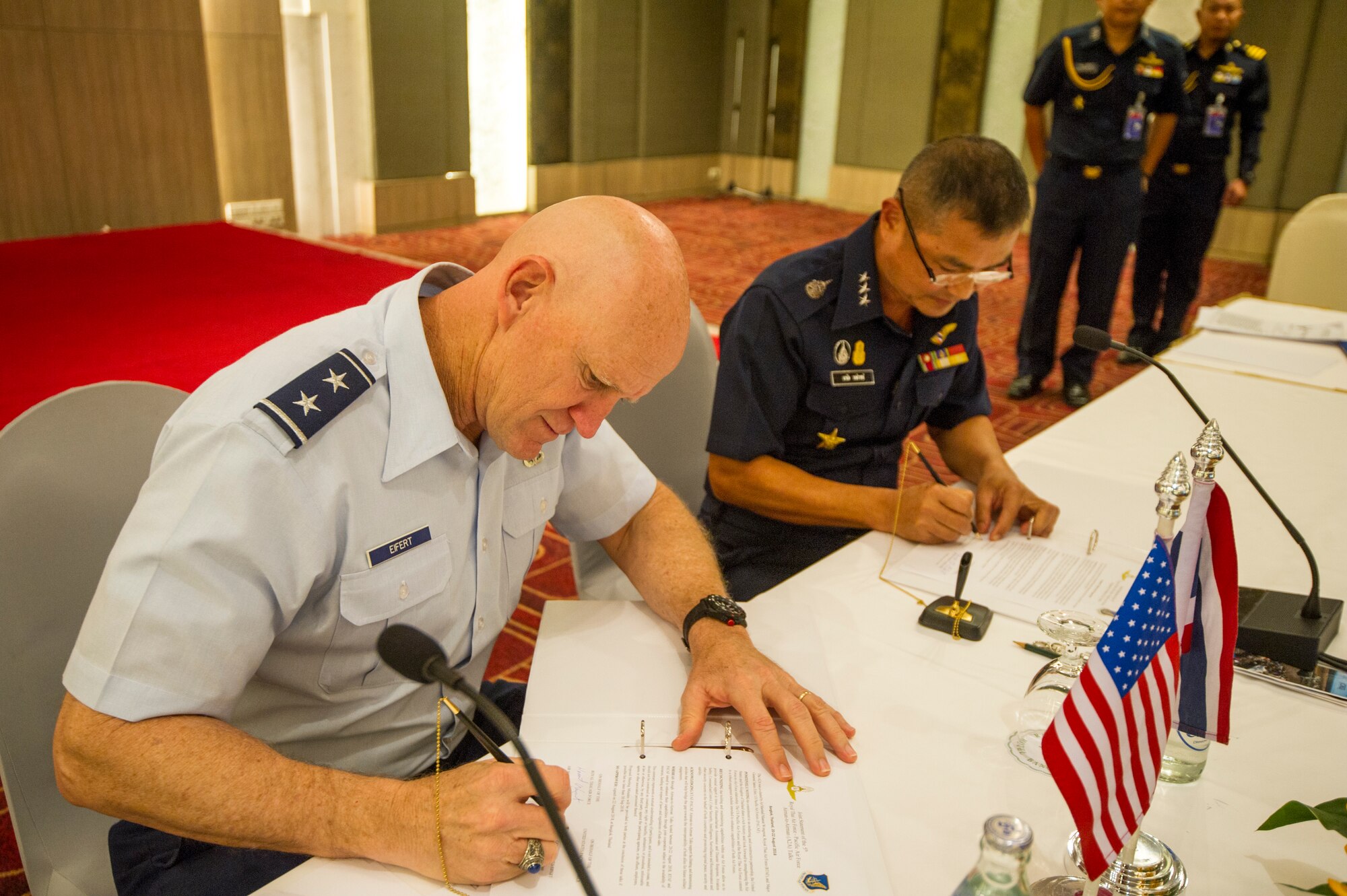 (Left) U.S. Air Force Maj. Gen. James Eifert, Air National Guard assistant to the commander, Pacific Air Forces (PACAF), and (right) Royal Thai Air Forces (RTAF) Air Marshal Maanat Wongwat, Deputy Chief of Air Staff, sign the meeting minutes for the fifth RTAF-PACAF Airman-to-Airman (A2A) talks in Bangkok, Thailand Aug. 22, 2018.