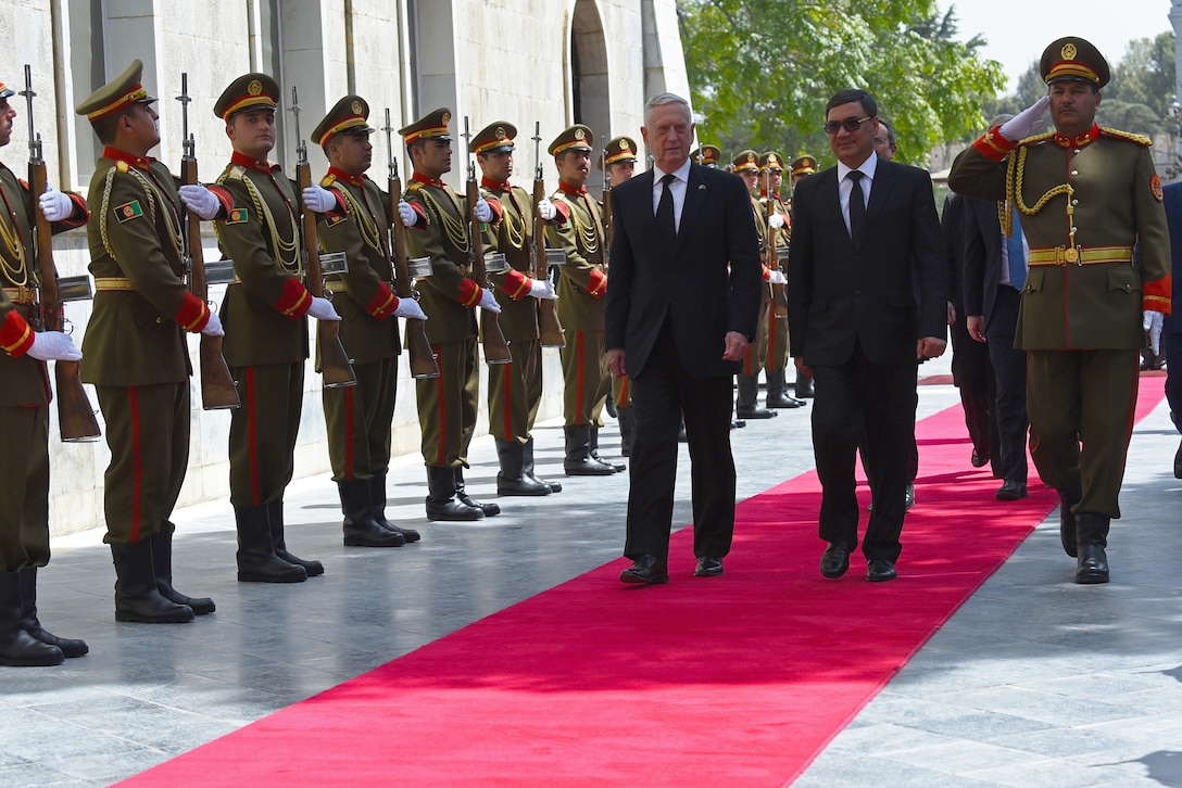 Defense Secretary James N. Mattis walks with an Afghan leader in front of Afghan troops.